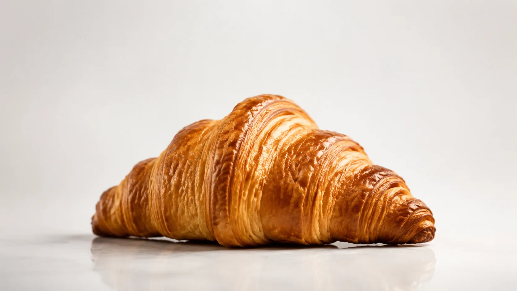 Goudbruine croissant in een minimalistische studio