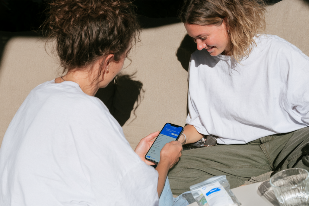 Twee vrouwen zitten op de bank en denken aan nieuwe skincare te kopen