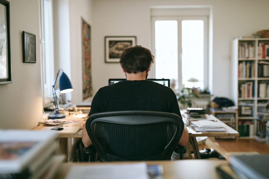 Jongen achter laptop aan het werk en probeert zijn trage webshop te optimaliseren