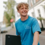 Simon van Rens, webdesigner in Amsterdam, met zijn laptop en fiets in een Amsterdamse straat