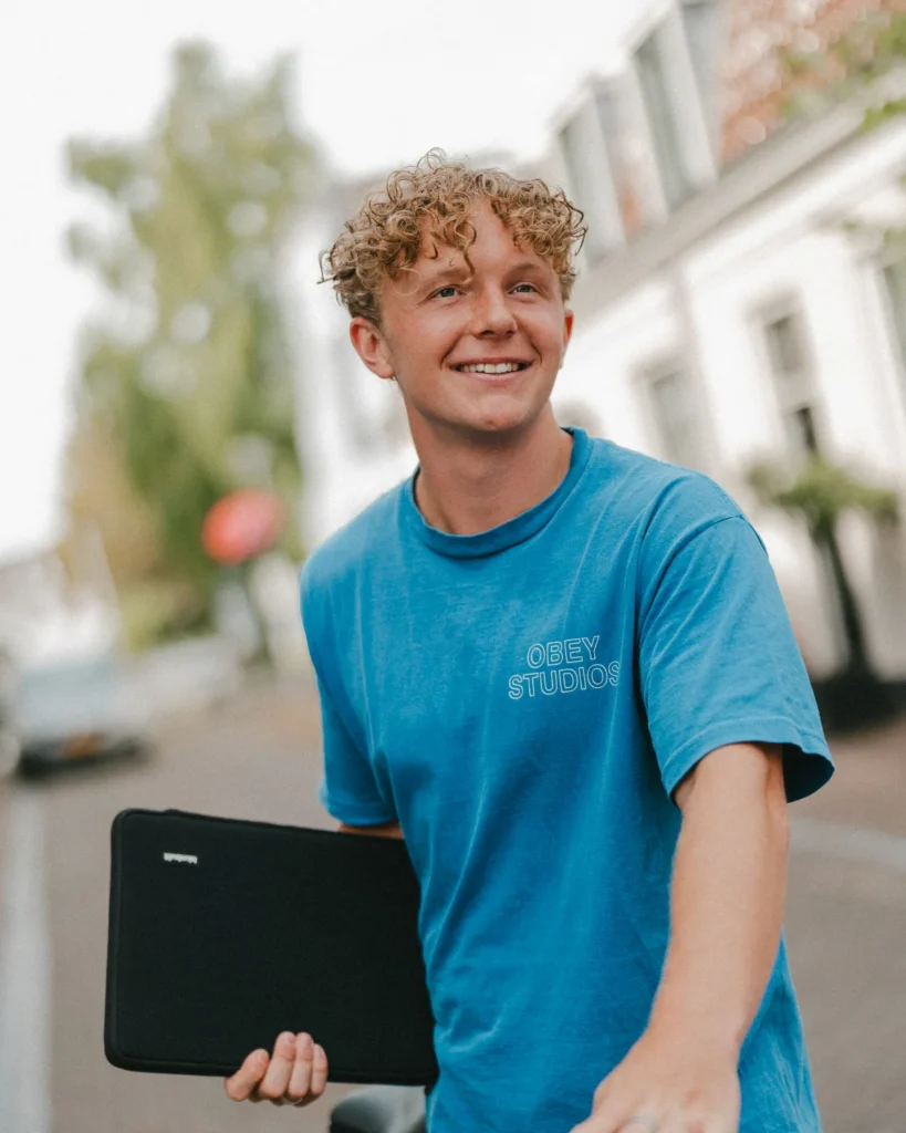 Simon van Rens, webdesigner in Amsterdam, met zijn laptop en fiets in een Amsterdamse straat